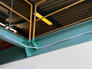 テープライトレールを使用してLEDテープライトを鉄骨梁へ固定した施工事例。マグネット固定によりビス不要で設置でき、鉄骨部の安全対策や視認性向上に活用。